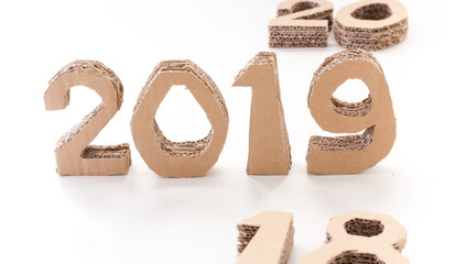 2019 with 18 down and 20 waiting handmade 3D numbers made of reused cardboard paper, on white background. New year concept.