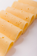Piece and slices of cheese on a white background