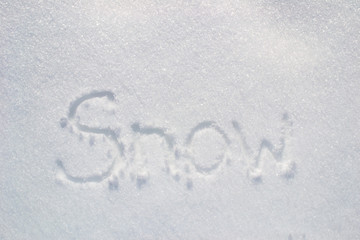 Winter concept . White snowy background / The word snow is written on the snow. 