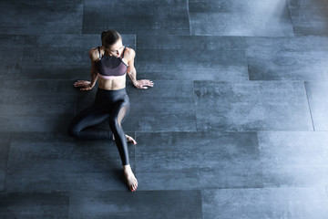 Athletic woman in a gym suit relaxing on the floor top view with copy space for text.