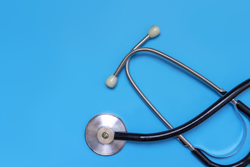 Stethoscope on blue background with copy space,flat lay, top view. Doctor and treatment concept