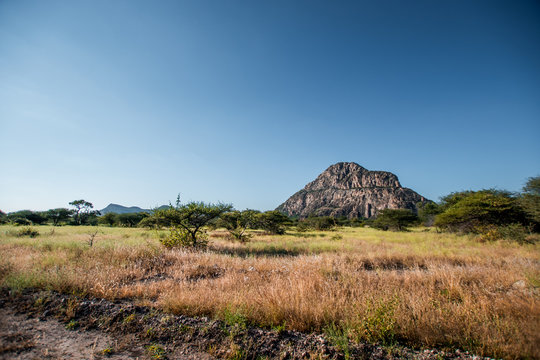 A view of the male hill at Tsodilo Hills, a UNESCO world heritage site featuring ancient San rock paintings. Pictured amid grassy and arid plains
