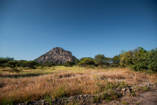 A view of the male hill at Tsodilo Hills, a UNESCO world heritage site featuring ancient San rock paintings. Pictured amid grassy and arid plains