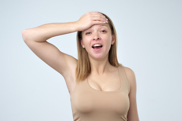 Fototapeta premium Forgetful woman holding hand on her head as she struggling to remember something.