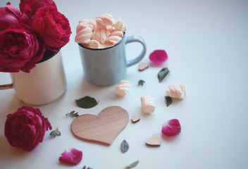a mug of coffee with marshmallows,wooden heart and pink roses/love/ valentines/birthday background with copy space