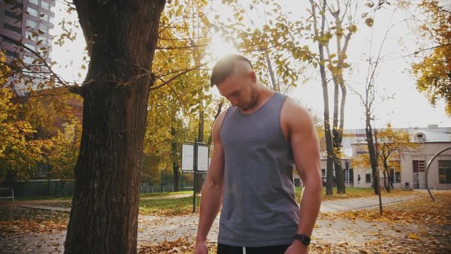 Young athlete does neck warm-up by rotating her in autumn park