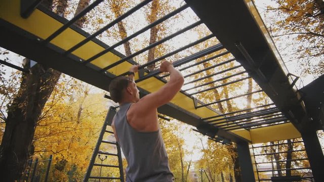 Young athlete uses monkey leopard in autumn parkv