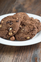 Soft dark chocolate brownie cookies on wood