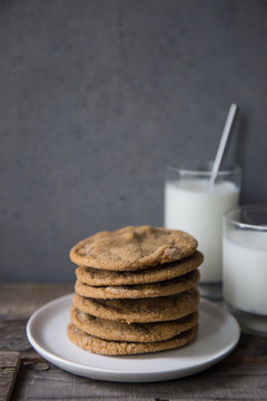 Stacked ginger cookies with milk and metal straw