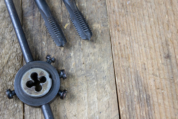 Metalwork tools on the workshop table. Threading dies and taps in an old dusty workshop.
