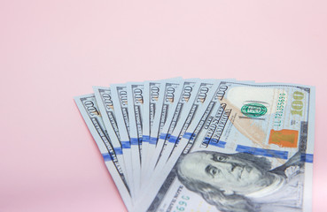 One hundred dollars banknotes on pink background. Flat lay, top view, copy space