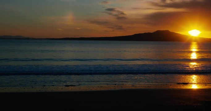 Sunrise over Rangitoto Island, Auckland, New Zealand. Person Walking past