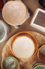 Ceramic tableware and cutlery on wooden background. Сoncept pottery of different colors. Top view, flatlay, сopy space for text.