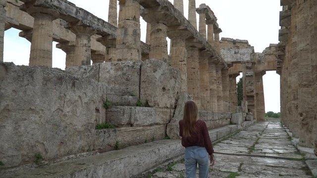 Pretty girl look at Second Temple of Hera  - a Greek temple in Paestum, Italy. 4K.