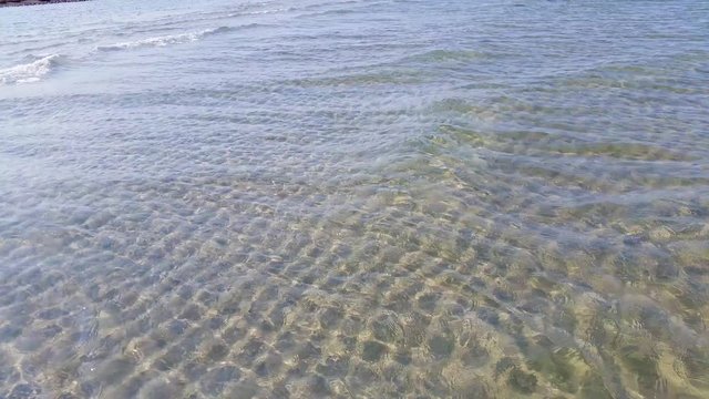 Pristine shallow and clear water with gentle waves. Beautiful ocean floor and water ripples. Liseleje Beach by Tisvilde forest and coastal area on the Danish island of Zealand.