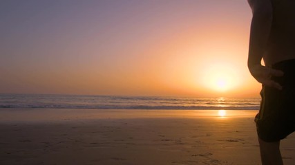Silhouette of father with two children in the beach at sunset