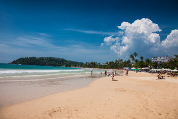 Tourists walking on the sand beach of Mirissa . Sri Lanka.