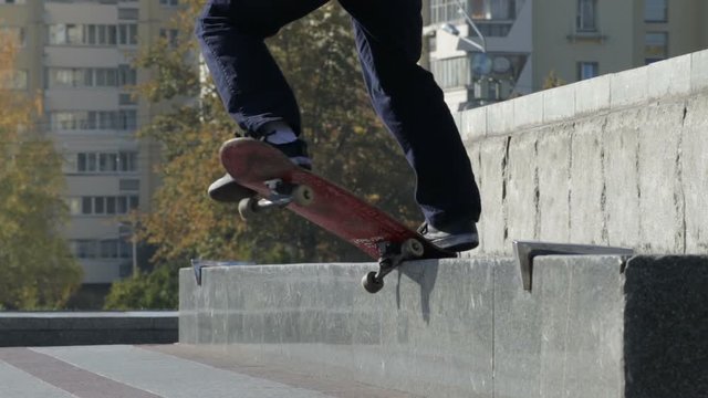 Skateboarder try a grind trick on ledge and skate truck stops slide, slowmotion