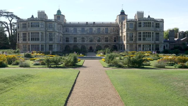 Far distant unidentifiable visitors stroll garden at Audley End a decadent Jacobean mansion house in Saffron Walden, Essex, England.