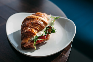 croissant with ham and cheese on a plate