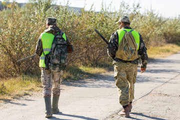 Naklejka premium Hunters with a german drathaar and spaniel, pigeon hunting with dogs in reflective vests
