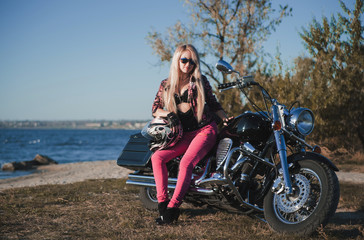 Fototapeta na wymiar Beautiful woman posing on motorcycle outdoor. 