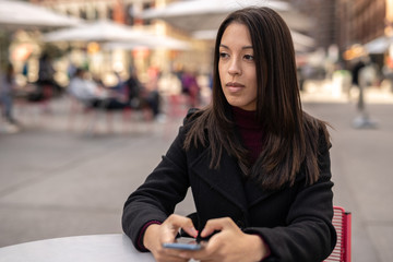 Young woman in city using cell phone using cell phone