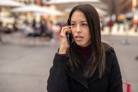 Young woman in city talking on cell phone