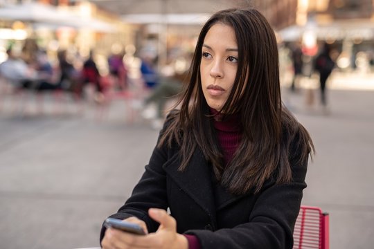 Young woman in city using cell phone using cell phone
