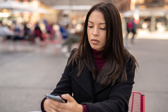Young woman in city using cell phone using cell phone