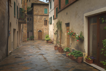 Flowery streets on a rainy spring day in a small magical village Pienza, Tuscany