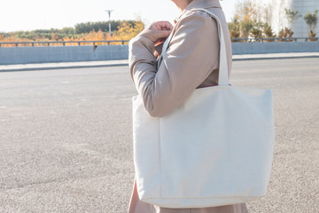 Woman holding white canvas bag