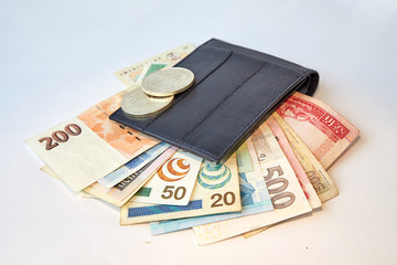 Background, black men's wallet with bills of various currencies, isolated