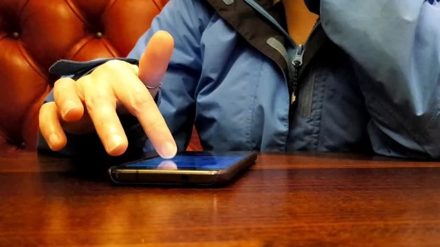 An adult using a mobile phone at the dinner table