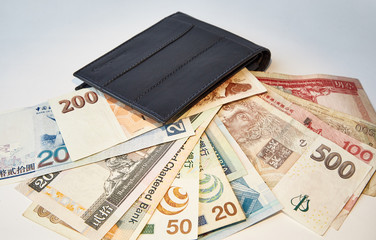 Background, black men's wallet with bills of various currencies, isolated