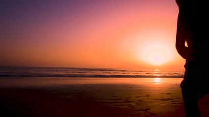 Silhouette of father with two children in the beach at sunset