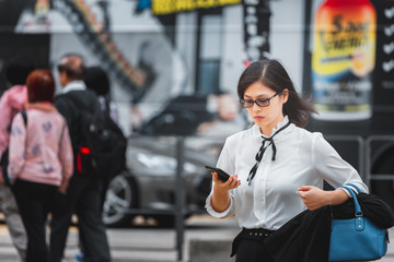 Business woman walking on crowded city street in Hong Kong
