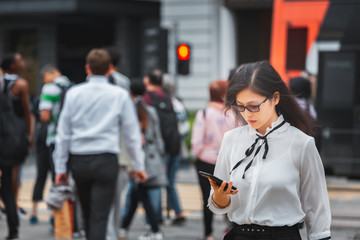 Business woman walking on crowded city street in Hong Kong