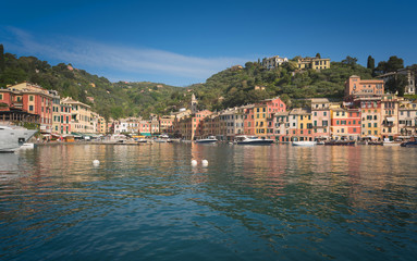 Fototapeta na wymiar The beautiful Portofino panorama with colorfull houses, luxury boats and yacht in little bay harbor. Liguria, Italy