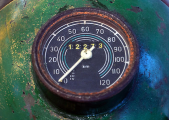 A old motorcycle speedometer installed on the motorcycle headlight, close-up view. © milkovasa