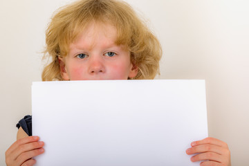 Fototapeta premium Child holds blank piece of paper