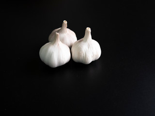 Three garlic has a spigot on black background dark tone