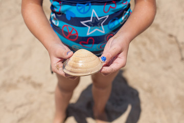 Child holding a sea shell