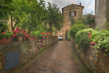 Flowery streets on a rainy spring day in a small magical village Pienza, Tuscany.