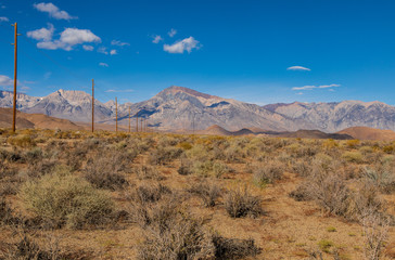 Fototapeta premium Black Mountain with open field and power lines running to the mountains
