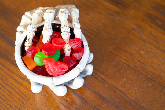 Skeleton Hand Grabbing Bowl Of Candy During Halloween