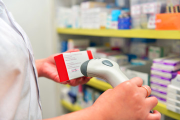 Pharmacist scanning barcode of medicine drug in a pharmacy drugstore