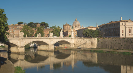 View of Vittorio Emanuele bridge on the Tiber river and St. Peter's Basilica in Vatican