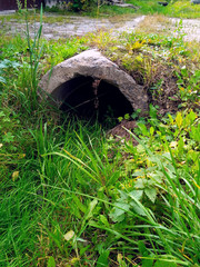 Drainage ditch with a pipe under a dirt road