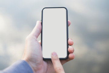Man's hands holding smart phone with white copy space screen, Shadow of the sky screen.